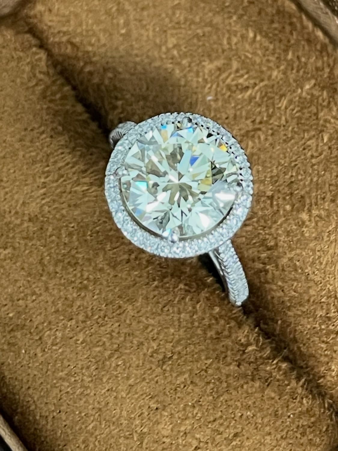 Round brilliant diamond halo engagement ring in a velvet ring box