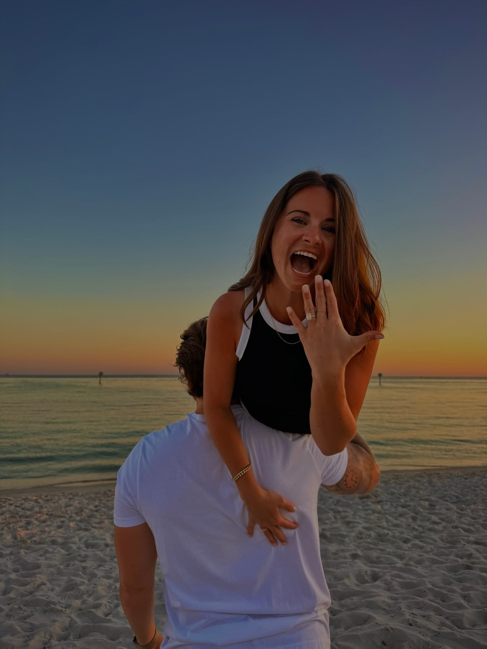 Customer celebrating a proposal at sunset on the beach