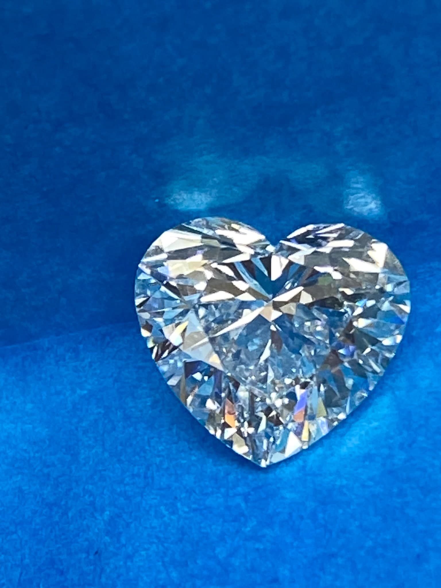 Loose heart-shaped diamond on a jewelers blue pad