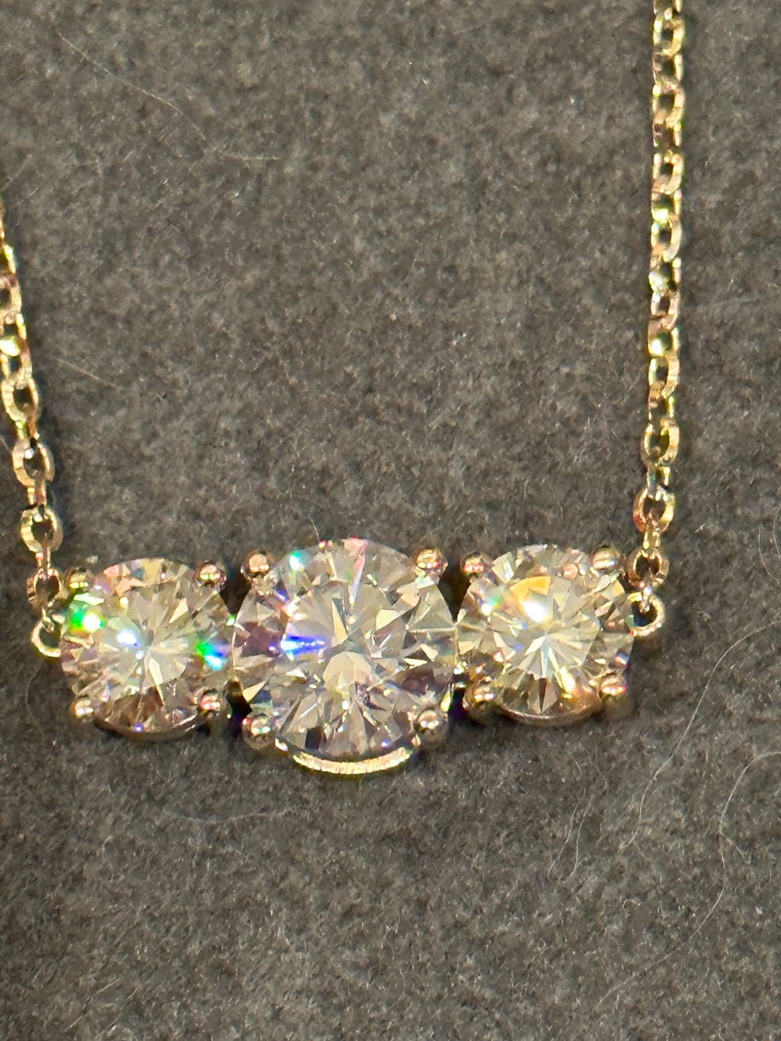 Three-stone diamond pendant on a yellow gold chain