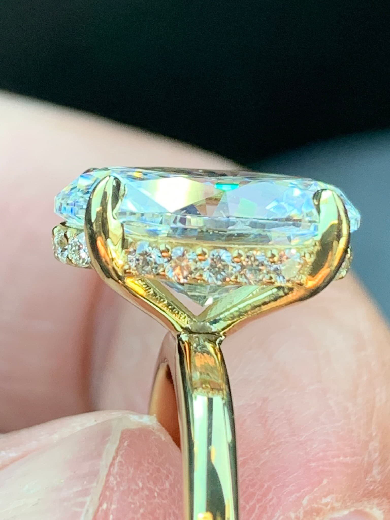 Yellow gold cushion-cut ring shown from the side, hidden halo visible