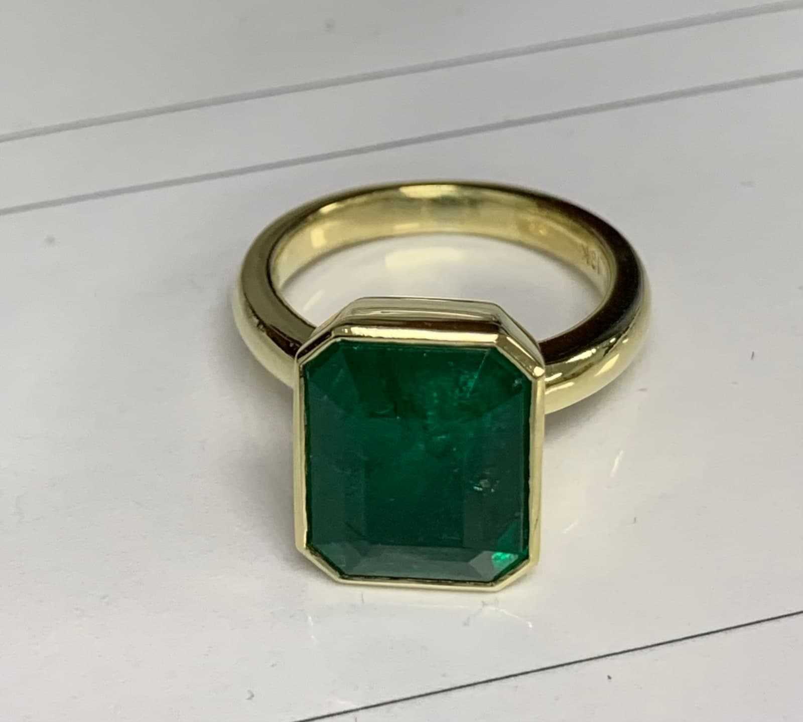 Bezel-set emerald in matte yellow gold